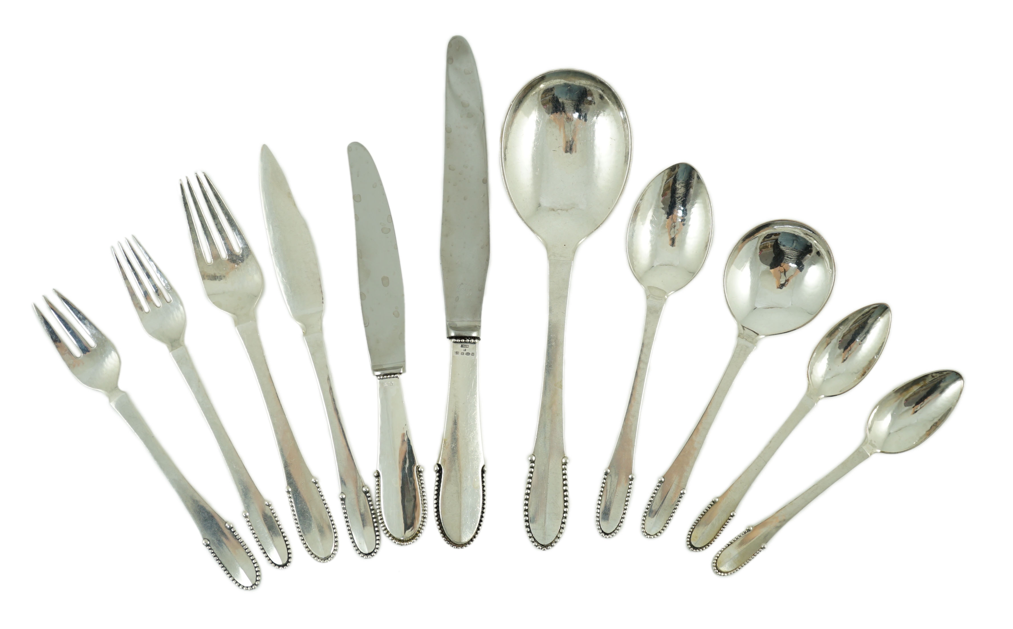 An early 20th century Georg Jensen canteen of beaded pattern silver cutlery